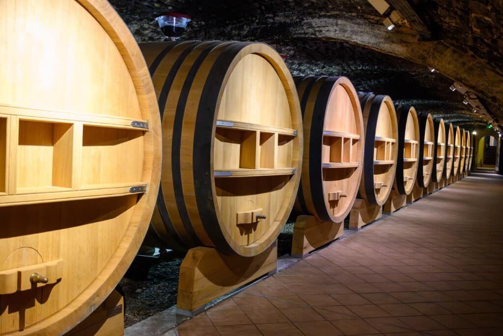 Underground wine cellars with barrels used for aging red dry wine in Châteauneuf-du-Pape