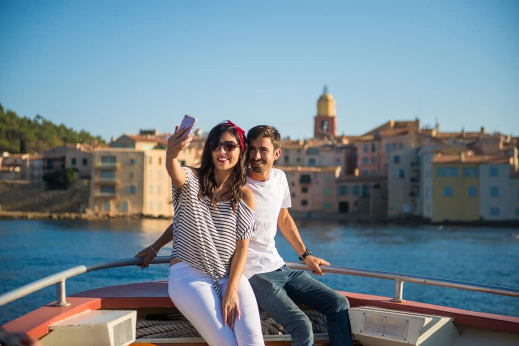 Honeymoon couple taking photos on a boat in Saint-Tropez, Provence