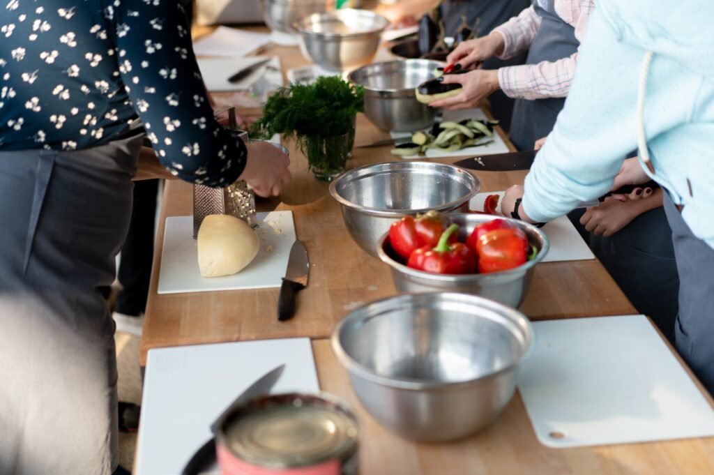 Travellers preparing eggplant and peppers during a hands-on cooking class in Provence