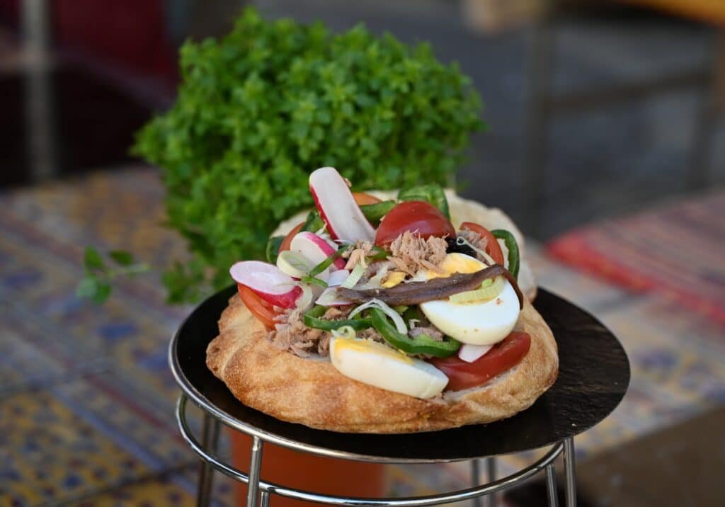 Traditional pain bagnat sandwich filled with tuna vegetables and olive oil, a classic Provençal street food