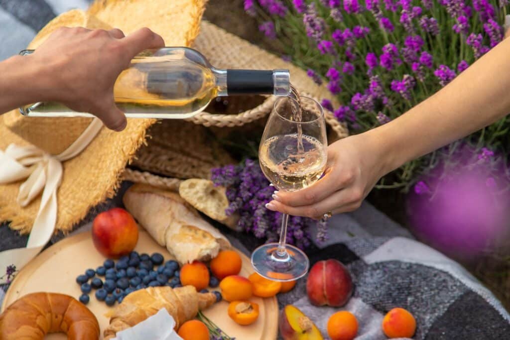 Glass of white wine on a picnic tablecloth in Provence, illustrating a gourmet food and wine experience near Châteauneuf-du-Pape