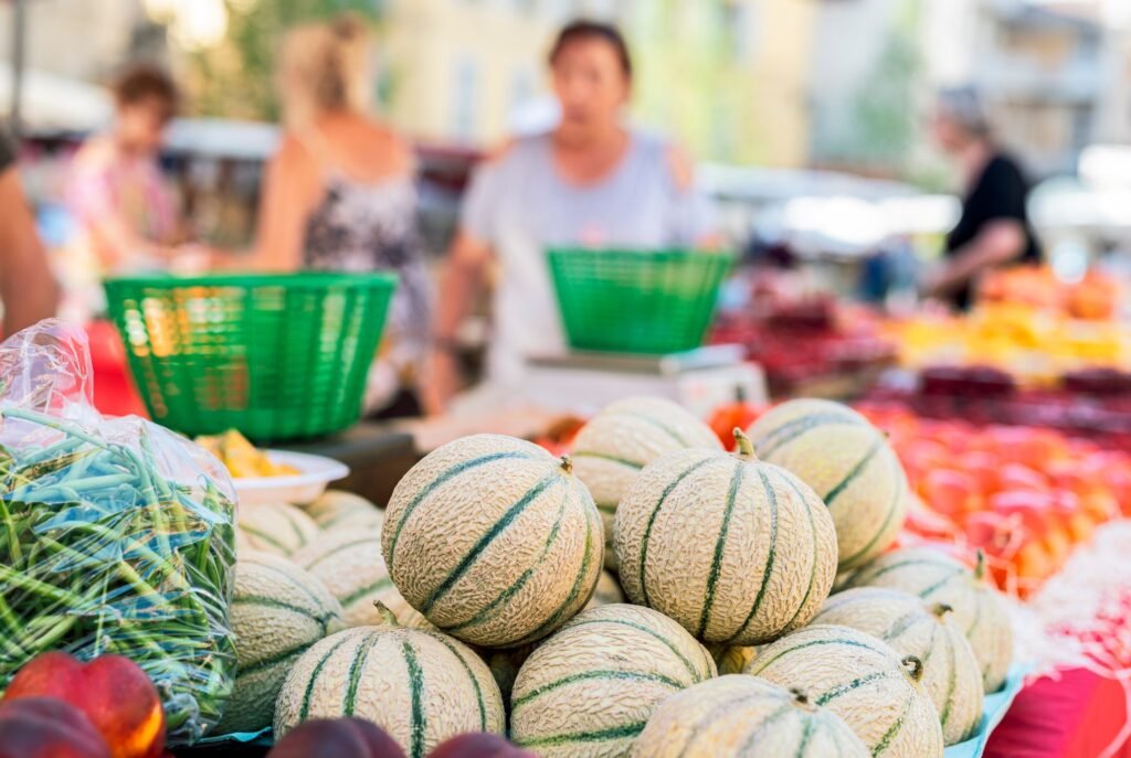 Fresh melons on a Provence market stall, showcasing local seasonal produce in a traditional Provençal farmers market