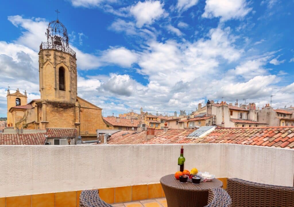 Terrace with aperitif overlooking the rooftops of Aix-en-Provence at sunset, showcasing a typical Provençal food experience